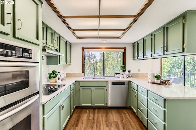 9080 NW Sherry Ct, Portland, OR 97229 - kitchen featuring appliances with stainless steel finishes, green cabinetry, a sink, and under cabinet range hood