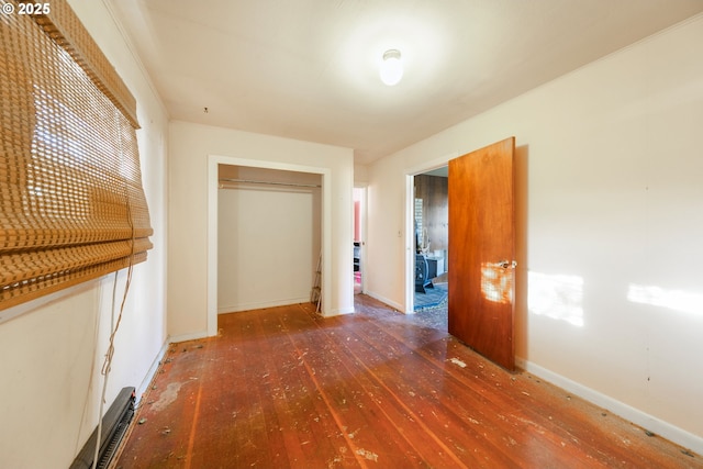 corridor featuring baseboards and hardwood / wood-style flooring