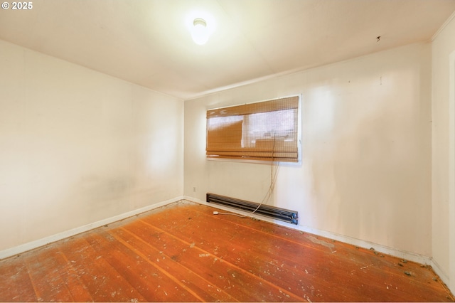 empty room featuring baseboards, visible vents, and hardwood / wood-style floors