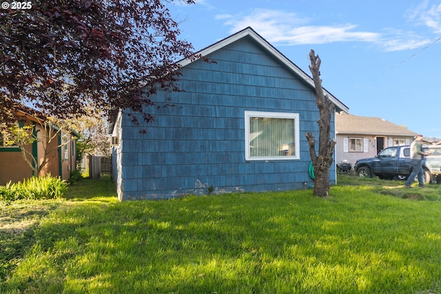view of side of property featuring fence and a yard