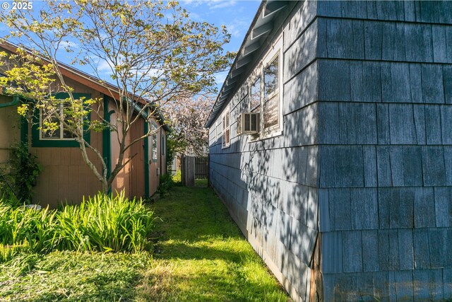 view of property exterior with a lawn and fence