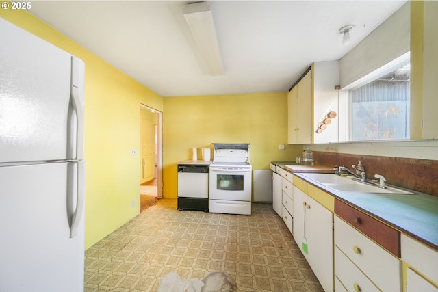 kitchen featuring white appliances, light floors, light countertops, white cabinets, and a sink