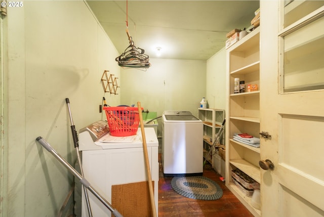 laundry area featuring dark wood-style flooring, laundry area, and washer and clothes dryer