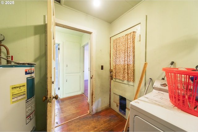 laundry area with laundry area, washer / dryer, water heater, and dark wood finished floors