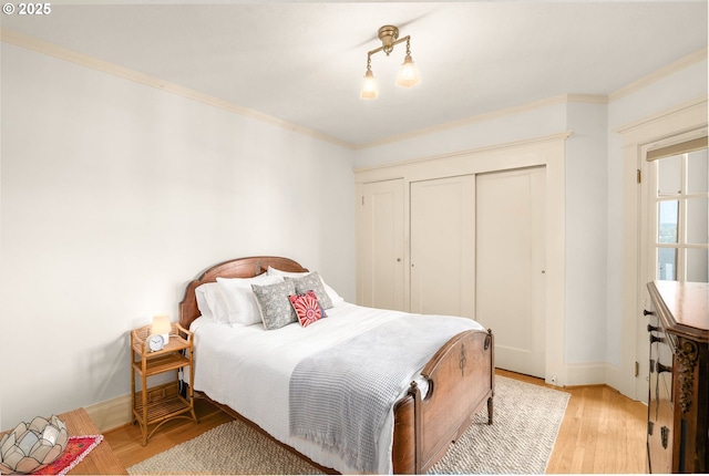 2083 NW Johnson St Unit 66, Portland, OR 97209 - bedroom with light wood finished floors, baseboards, crown molding, and a closet