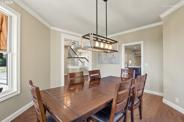 dining space with stairs, baseboards, and wood finished floors