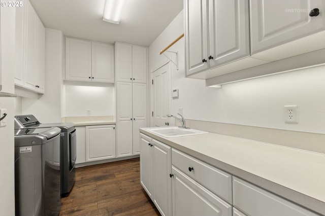 clothes washing area featuring dark wood-type flooring, a sink, cabinet space, and washer and dryer