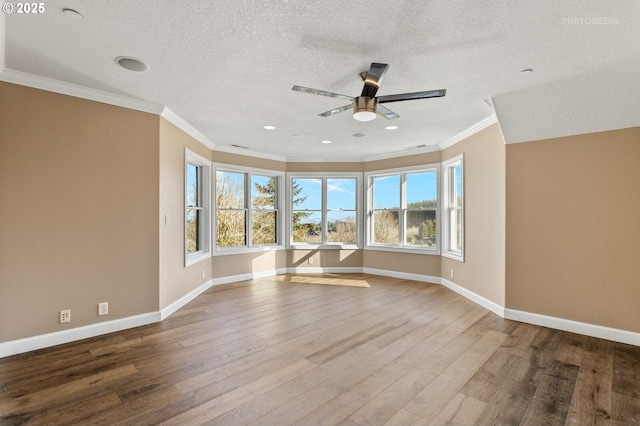 unfurnished room featuring crown molding, wood finished floors, a ceiling fan, and baseboards