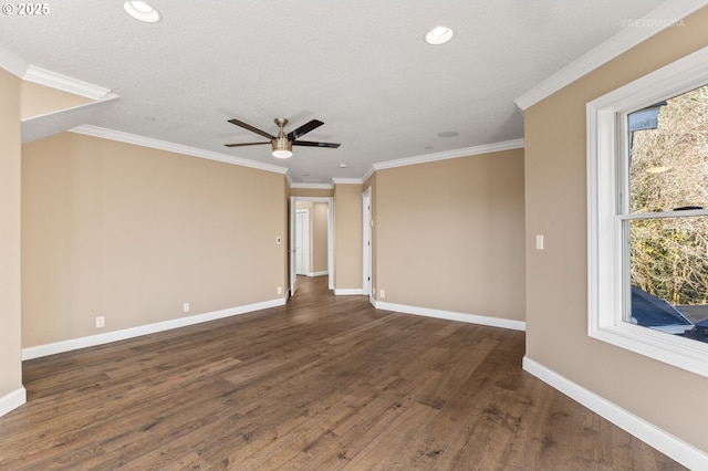 empty room featuring a textured ceiling, baseboards, crown molding, and wood finished floors