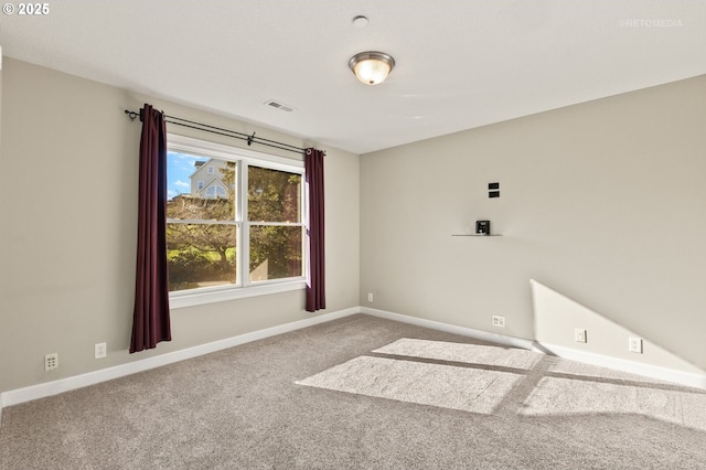 carpeted spare room featuring visible vents and baseboards