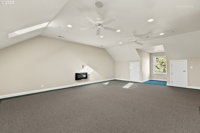 bonus room with vaulted ceiling with skylight, visible vents, baseboards, and ceiling fan