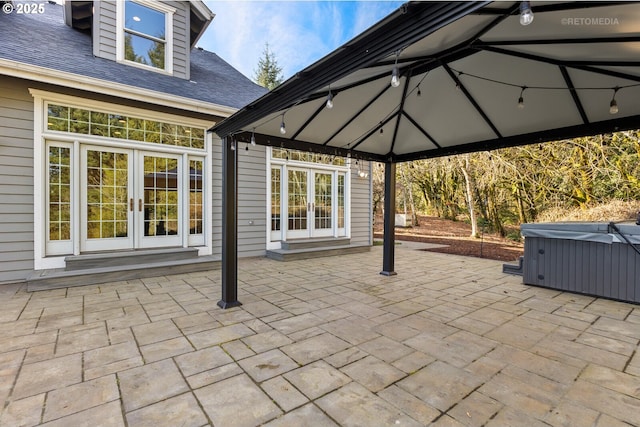 view of patio with a gazebo, a hot tub, and french doors