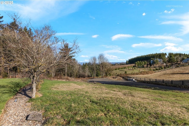 view of yard with a rural view and fence