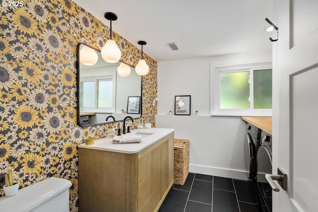 10701 SE Stevens Way, Happy Valley, OR 97086 - bathroom featuring wallpapered walls, toilet, separate washer and dryer, tile patterned floors, and baseboards
