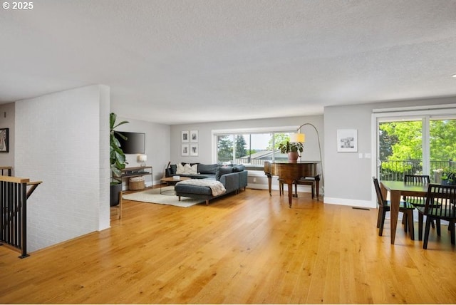 10701 SE Stevens Way, Happy Valley, OR 97086 - living room featuring light wood-type flooring, baseboards, and a textured ceiling