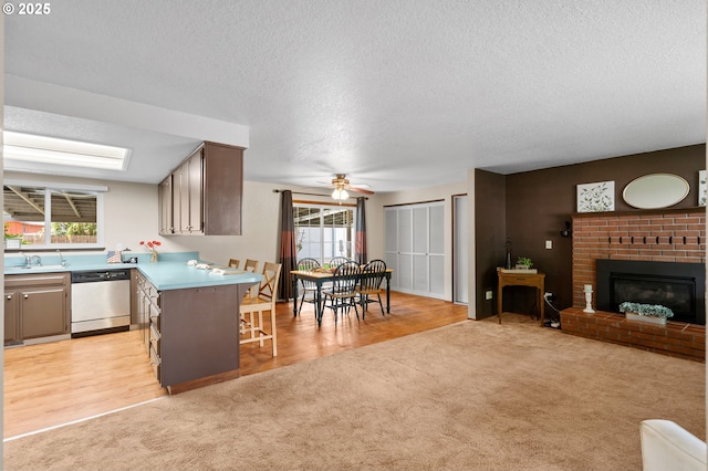 1911 SW Vista Pl, Pendleton, OR 97801 - kitchen featuring dishwasher, light colored carpet, a breakfast bar, a peninsula, and a textured ceiling