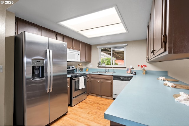1911 SW Vista Pl, Pendleton, OR 97801 - kitchen featuring stainless steel appliances, a sink, light wood finished floors, dark brown cabinetry, and light countertops