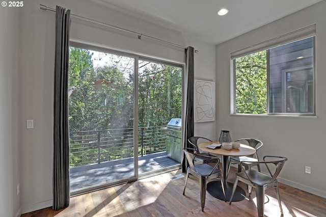 dining area with baseboards, wood finished floors, and recessed lighting