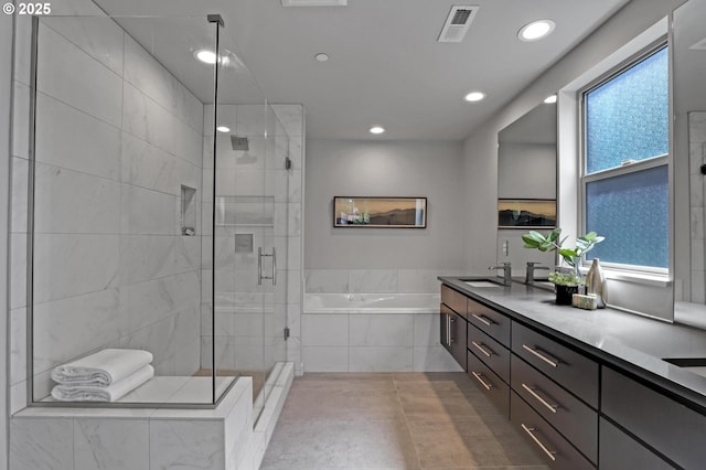 bathroom with a garden tub, a shower stall, recessed lighting, and double vanity