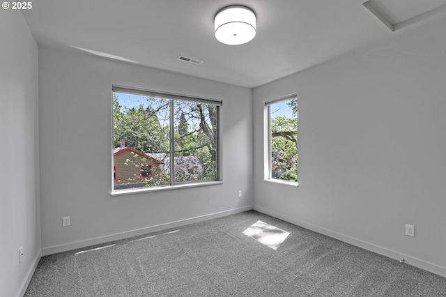 carpeted empty room featuring baseboards