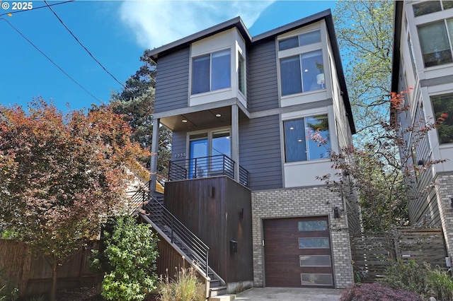 view of front of home featuring stairs, brick siding, fence, and a garage