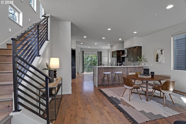 dining space featuring stairs, recessed lighting, hardwood / wood-style flooring, and baseboards