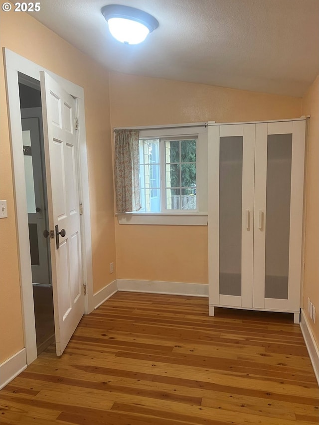 6433 NE 35th Ave, Portland, OR 97211 - unfurnished bedroom with vaulted ceiling, wood-type flooring, and a closet