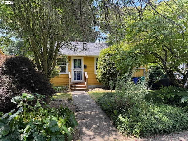 6433 NE 35th Ave, Portland, OR 97211 - view of property hidden behind natural elements with roof with shingles and entry steps