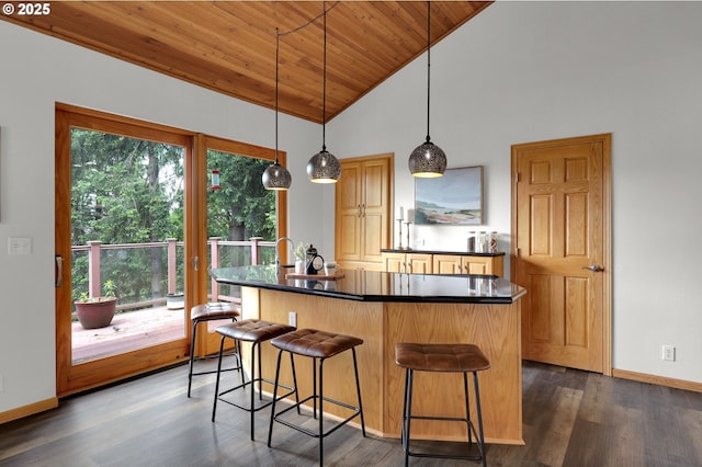 3758 Pine Canyon Dr, Eugene, OR 97405 - kitchen with dark countertops, wooden ceiling, dark wood-style flooring, a kitchen island with sink, and a breakfast bar