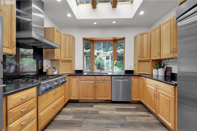 3758 Pine Canyon Dr, Eugene, OR 97405 - kitchen with stainless steel appliances, wall chimney exhaust hood, a sink, light wood finished floors, and dark countertops