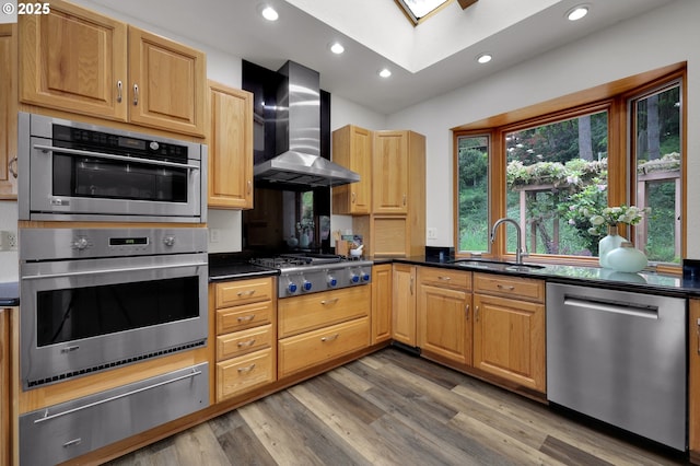 3758 Pine Canyon Dr, Eugene, OR 97405 - kitchen featuring appliances with stainless steel finishes, a warming drawer, wall chimney range hood, a sink, and a skylight