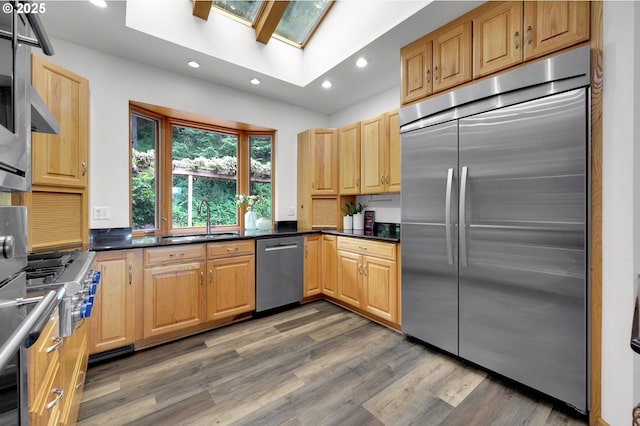 3758 Pine Canyon Dr, Eugene, OR 97405 - kitchen featuring appliances with stainless steel finishes, recessed lighting, a skylight, a sink, and dark countertops