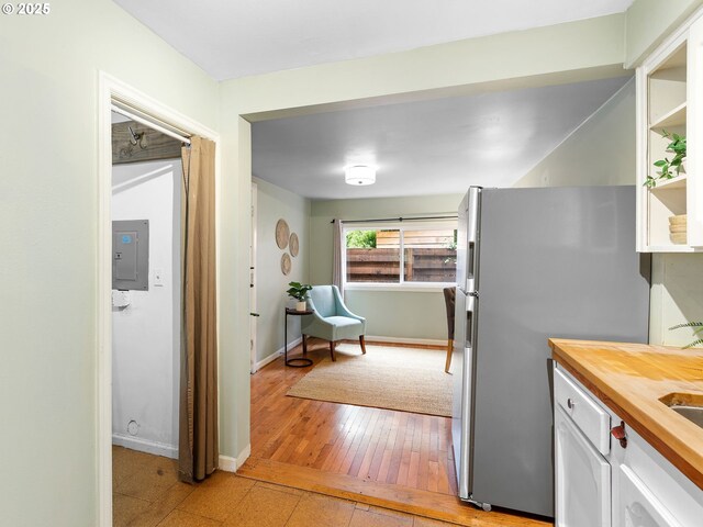 3516 N Missouri Ave, Portland, OR 97227 - kitchen with wood counters, freestanding refrigerator, electric panel, white cabinets, and light wood finished floors