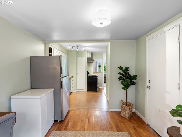 3516 N Missouri Ave, Portland, OR 97227 - kitchen featuring white fridge, light wood finished floors, freestanding refrigerator, wall chimney exhaust hood, and white cabinetry