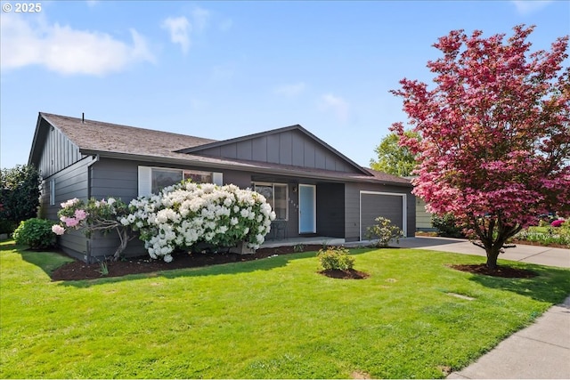 2242 W Hayes St, Woodburn, OR 97071 - view of front of house featuring board and batten siding, a front yard, concrete driveway, and an attached garage