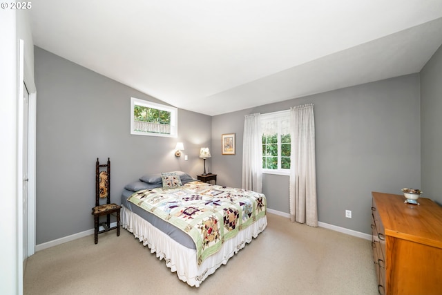 bedroom with baseboards, light carpet, and lofted ceiling
