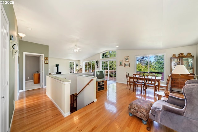 interior space with baseboards, light wood-style flooring, ceiling fan, and lofted ceiling
