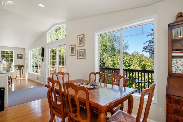 dining room featuring recessed lighting, baseboards, vaulted ceiling, and light wood-style flooring