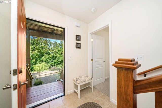 doorway to outside with light tile patterned flooring and baseboards