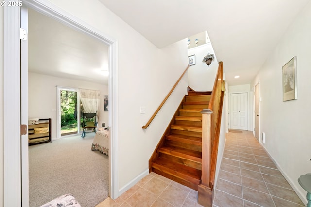 stairway featuring tile patterned floors and baseboards