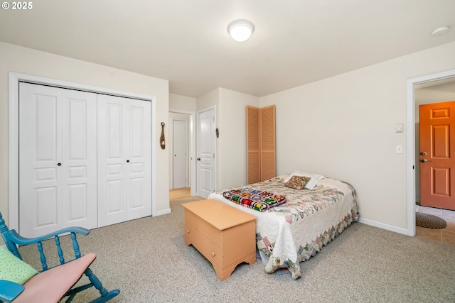 bedroom with baseboards, a closet, and light colored carpet