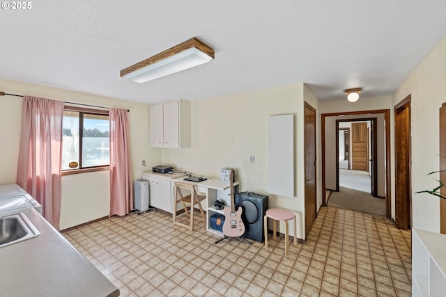 kitchen with a sink, white cabinets, light countertops, radiator, and light floors