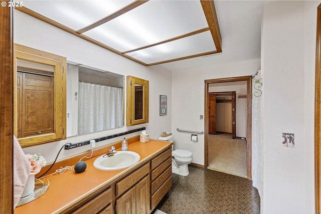 bathroom featuring toilet, vanity, and baseboards