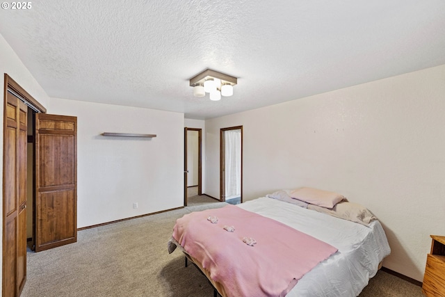 bedroom featuring a textured ceiling, baseboards, and carpet flooring