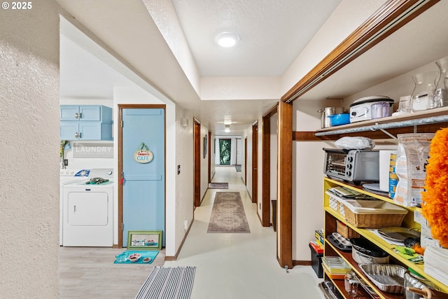 corridor with washer / clothes dryer and a textured wall