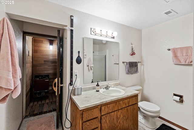 full bathroom with a textured ceiling, toilet, vanity, visible vents, and a stall shower