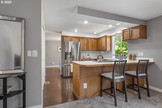 11595 SW Fairview Ln, Tigard, OR 97223 - kitchen featuring stainless steel fridge, a peninsula, brown cabinetry, recessed lighting, and light countertops