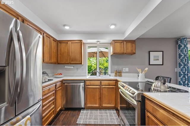 11595 SW Fairview Ln, Tigard, OR 97223 - kitchen featuring appliances with stainless steel finishes, a sink, brown cabinetry, and tile counters