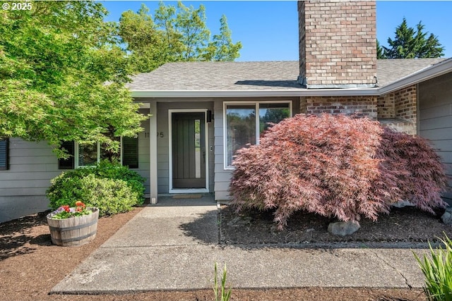 11595 SW Fairview Ln, Tigard, OR 97223 - view of exterior entry with a chimney and roof with shingles