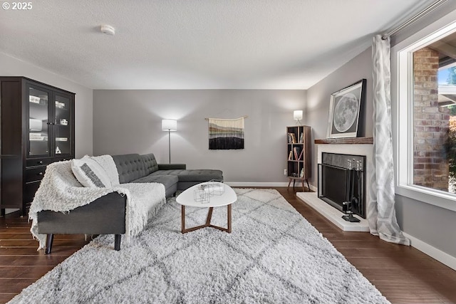 11595 SW Fairview Ln, Tigard, OR 97223 - living room with dark wood-style floors, a fireplace with raised hearth, baseboards, and a textured ceiling
